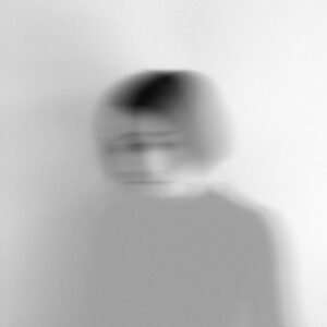 Artistic blurred grayscale portrait capturing motion and emotion.